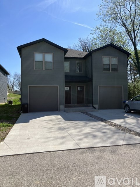 A two-story house with a garage is available for sale.