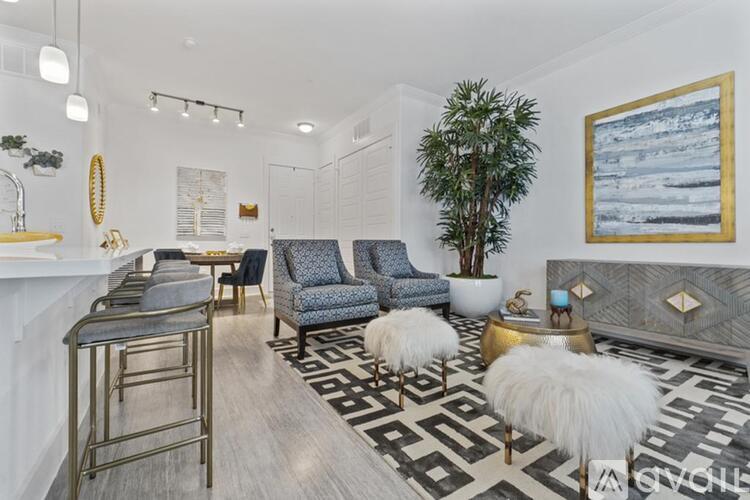 A living room with a black and white rug and a blue chair.
