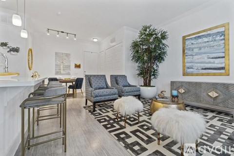 A living room with a black and white rug and a blue chair.