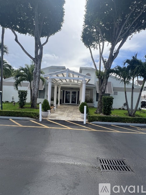 A white building with a tree in front of it.
