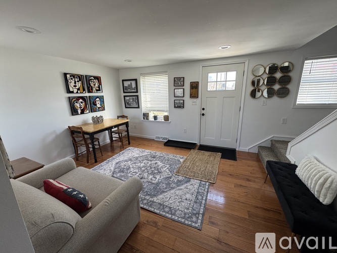 A living room with a couch, a table, and pictures on the wall.
