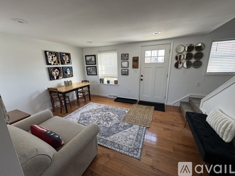 A living room with a couch, a table, and pictures on the wall.