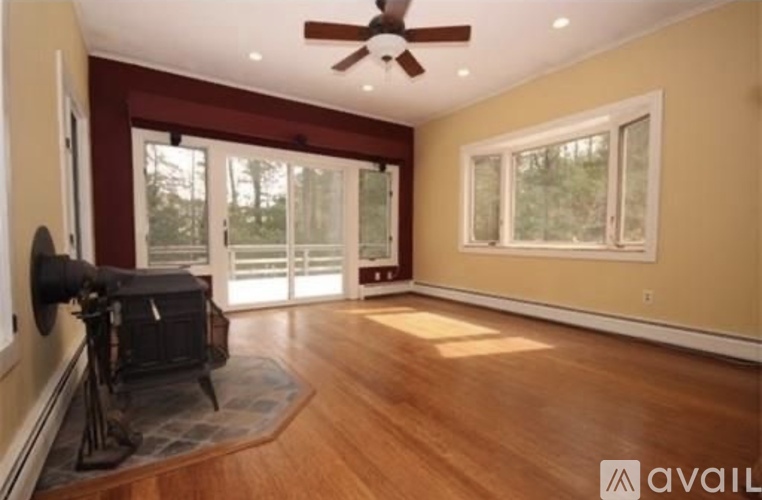 A room with a ceiling fan and a fireplace.