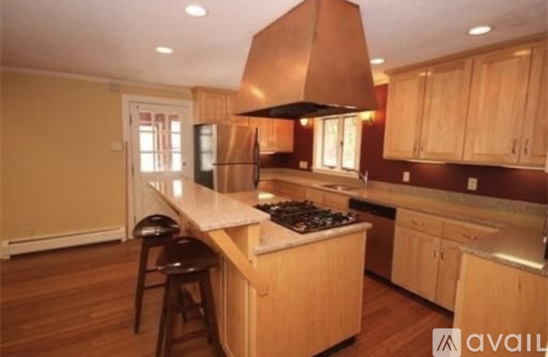A kitchen with wooden cabinets and a copper hood.