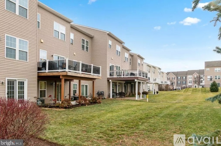 A row of apartment buildings with balconies and green lawns.