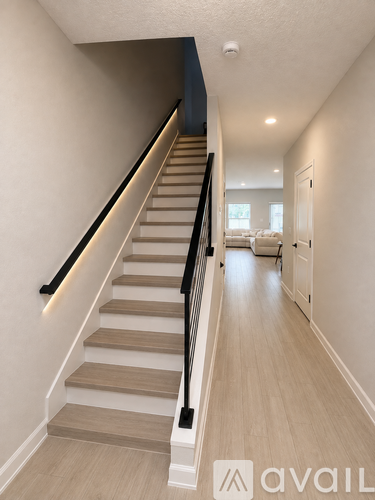 A staircase with a beige carpeted runner and black handrails.