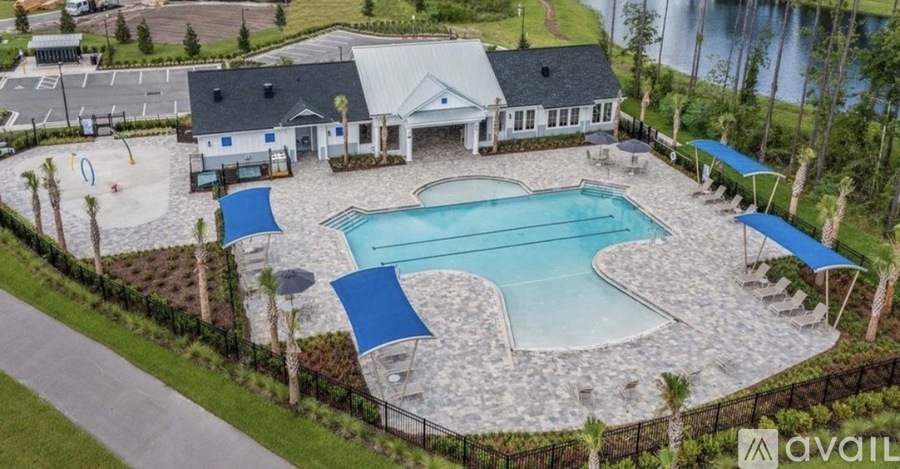 A swimming pool surrounded by a fence and a building in the background.