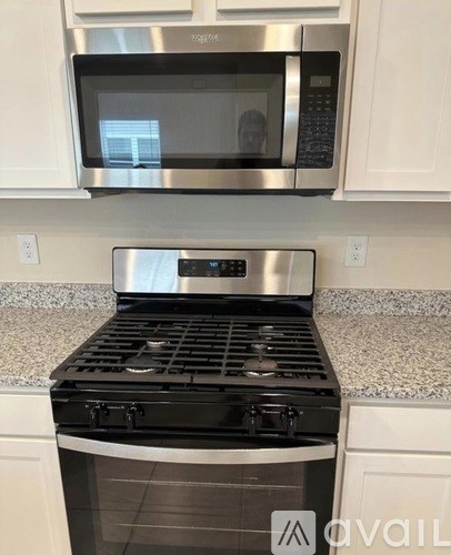 A modern kitchen with a stainless steel microwave and oven.