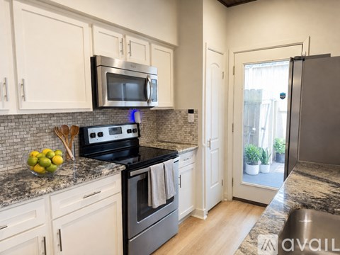 A kitchen with a black stove top oven and a black microwave above it.