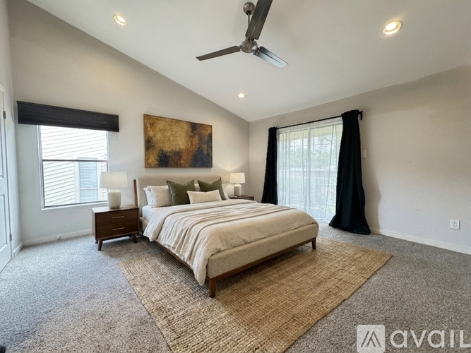 A bedroom with a large bed and a ceiling fan.