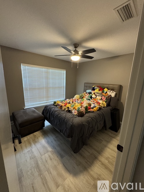 A bedroom with a bed covered in flowers and a ceiling fan.