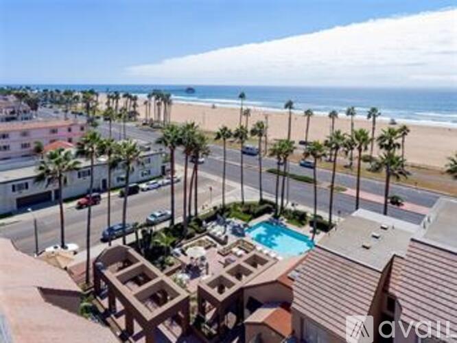 A beachfront property with a pool and palm trees.