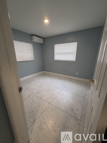 A room with a tiled floor and a window with blinds.