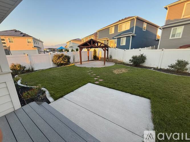 A backyard with a gazebo and a concrete patio.