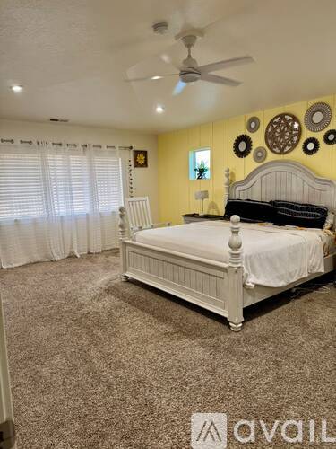 A bedroom with a large bed and a ceiling fan.