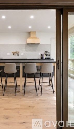A kitchen with a table and chairs in front of a window.