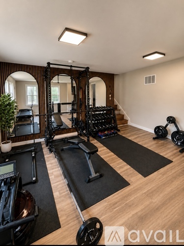 A home gym with a variety of equipment including a treadmill, weights, and a bench press.