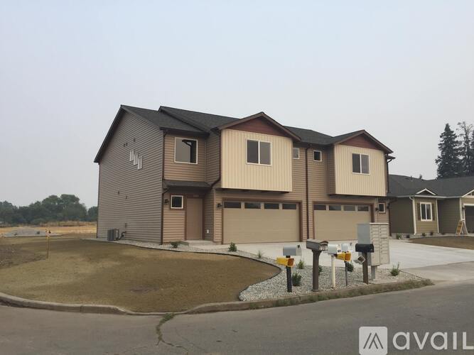 A row of houses with the first one having a garage door that is open.