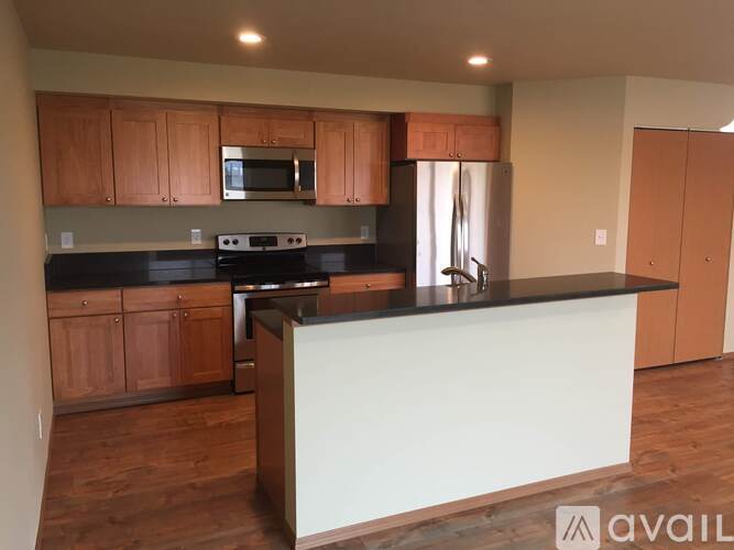 A kitchen with wooden cabinets and a black countertop.