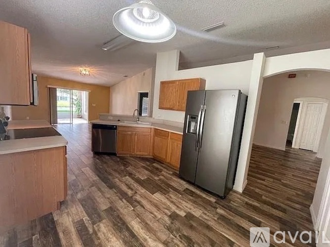 A kitchen with wooden cabinets and a black refrigerator.