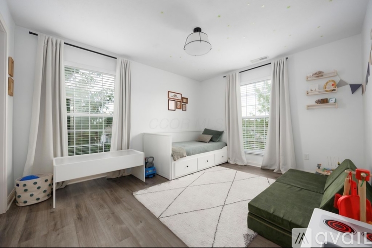 A bedroom with a white bed and a white bench.