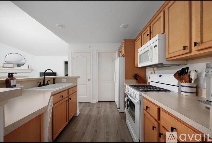 A kitchen with wooden cabinets and a white fridge.