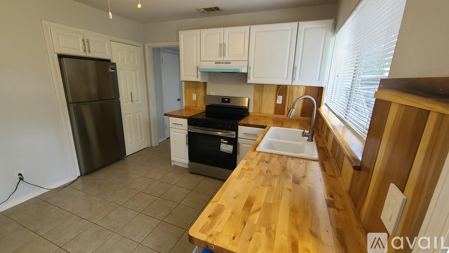 A kitchen with a wooden counter top and stainless steel appliances.