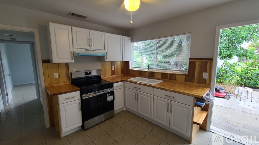 A kitchen with white cabinets and a black stove top oven.