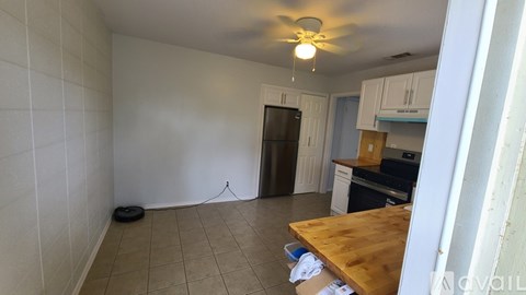 A kitchen with a wooden table and a ceiling fan.