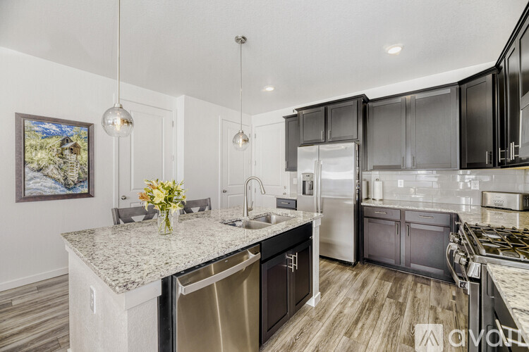 A kitchen with a granite countertop and stainless steel appliances.