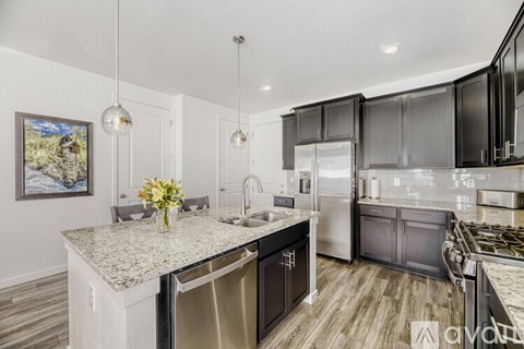 A kitchen with a granite countertop and stainless steel appliances.