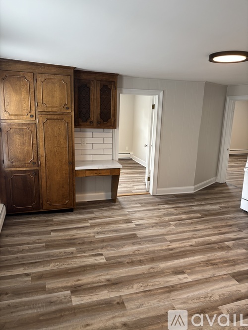 A kitchen with wooden floors and cabinets.