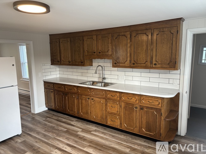 A kitchen with wooden cabinets and a white fridge.