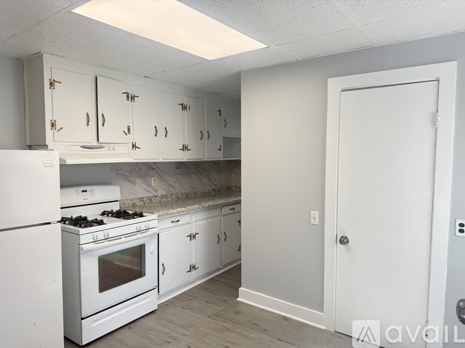A kitchen with white appliances and cabinets.