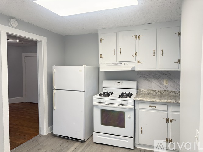 A kitchen with white appliances and cabinets.