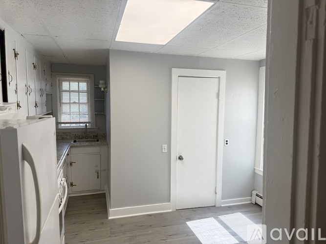 A kitchen with white appliances and cabinets.