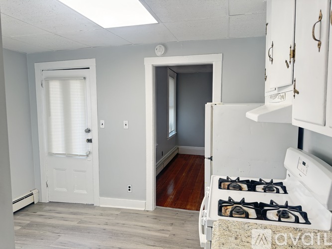 A kitchen with a white stove and cabinets.
