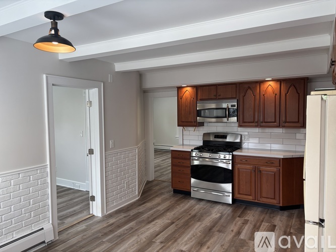 A kitchen with wooden cabinets and a brick wall.