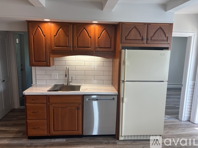 A kitchen with wooden cabinets and a white fridge.