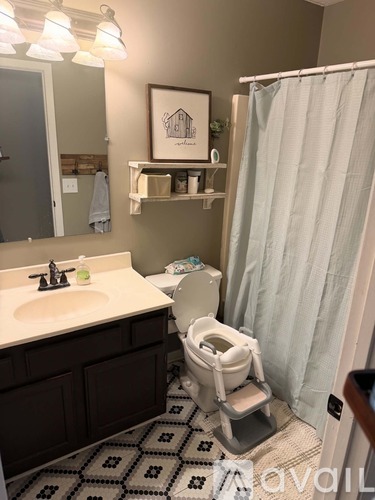 A bathroom with a toilet, sink, and shower.