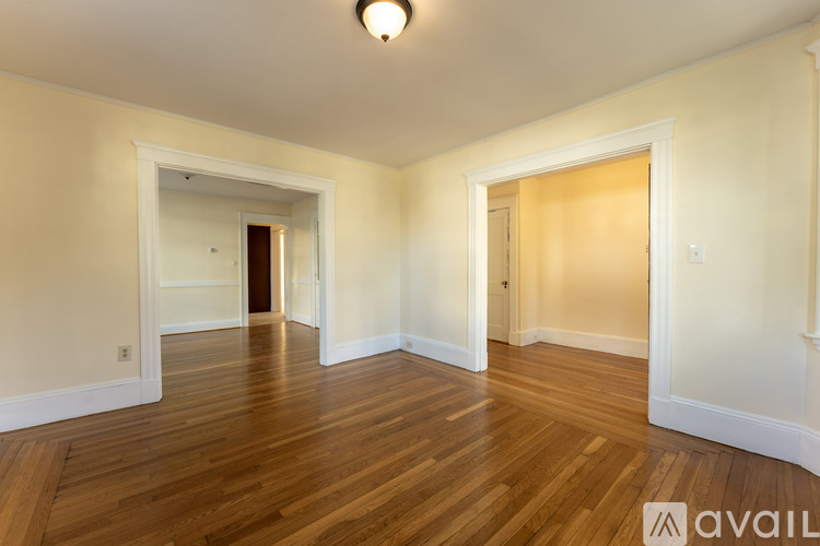 A spacious room with wooden floors and white walls.