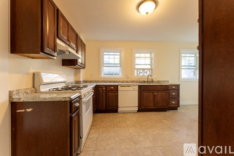 A kitchen with brown cabinets and a granite countertop.