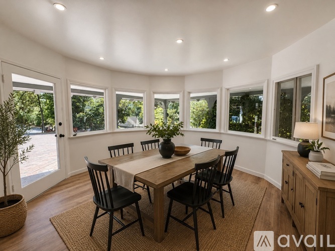A dining room with a round table and chairs.