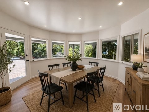A dining room with a round table and chairs.