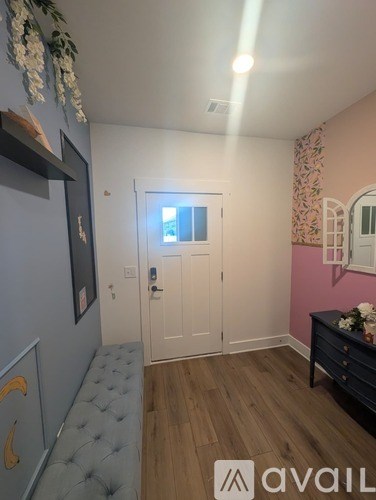 A room with a grey bench and a white door.