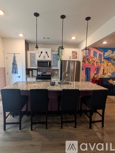 A kitchen with a table and chairs in front of it.