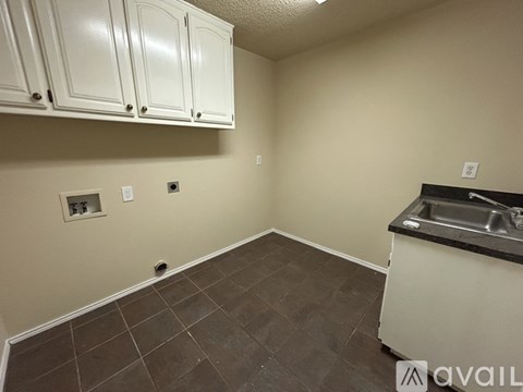 A kitchen with white cabinets and a black countertop.