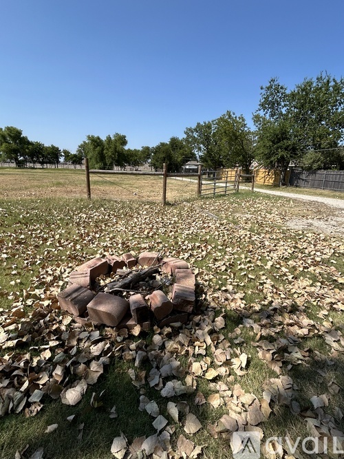 A pile of wood is in the middle of a grassy area.