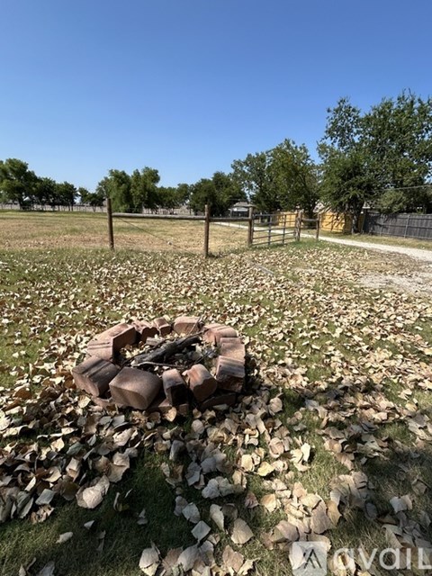 A pile of wood is in the middle of a grassy area.