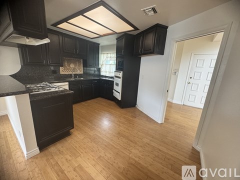 A kitchen with black cabinets and a white stove top oven.